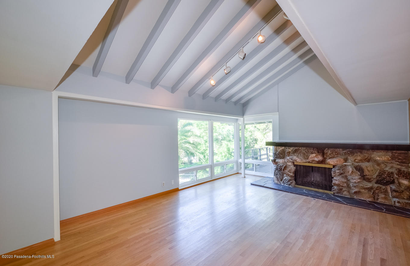 588 Glen Holly Drive Pasadena, CA 91105 - Photo 5 of 31 an empty room with wooden floor a fireplace and windows