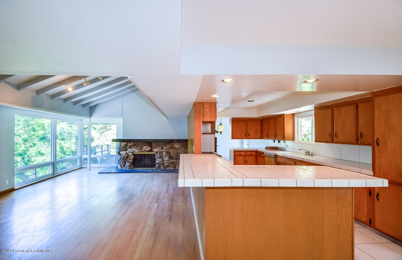 588 Glen Holly Drive Pasadena, CA 91105 - Photo 7 of 31 a kitchen with sink refrigerator and large window