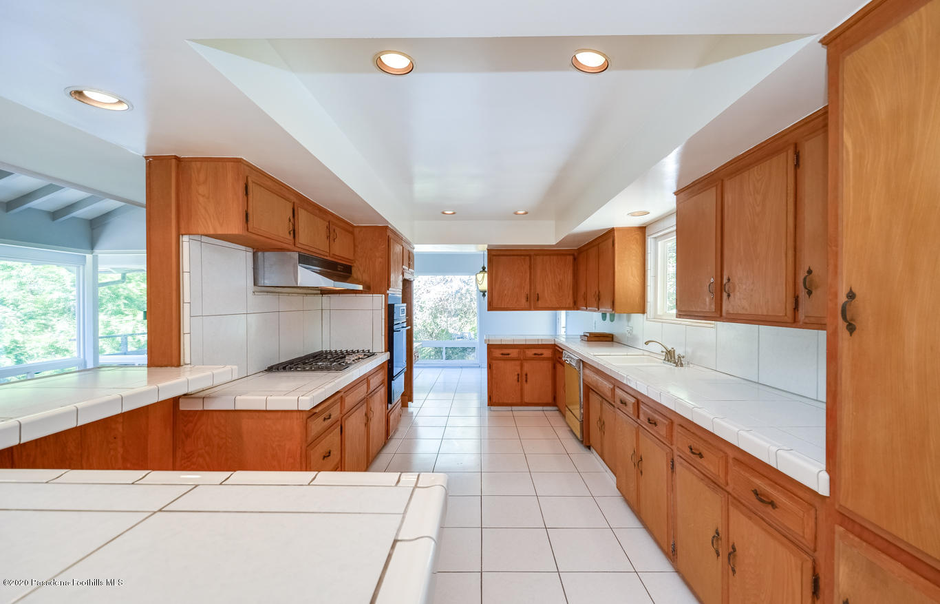 588 Glen Holly Drive Pasadena, CA 91105 - Photo 9 of 31 a large kitchen with stainless steel appliances kitchen island granite countertop a sink and cabinets