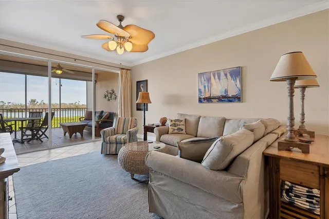 a living room with furniture a chandelier and a floor to ceiling window