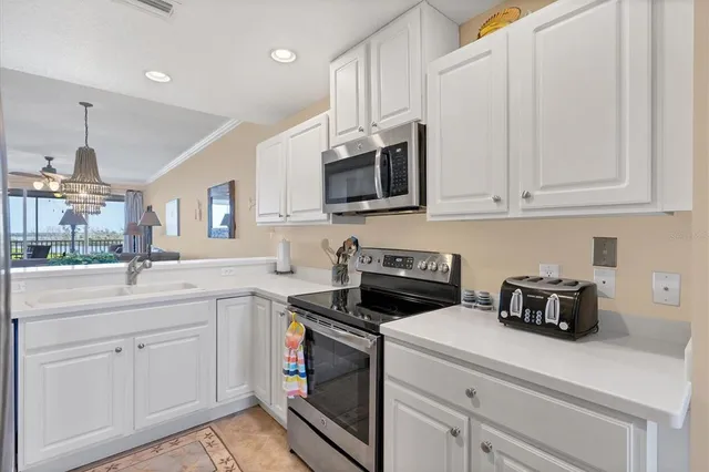 a kitchen with white cabinets and white appliances