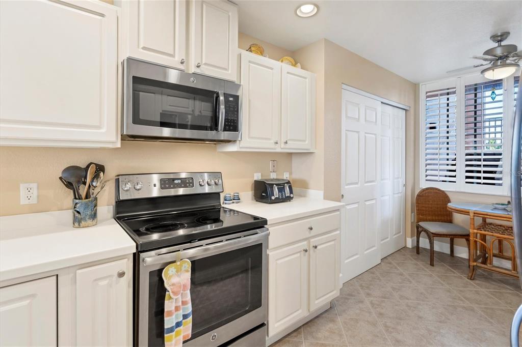 13313 Gasparilla Road, Unit 204 Placida, FL 33946 - Photo 7 of 28 a kitchen with stainless steel appliances a stove a sink a microwave cabinets and a window