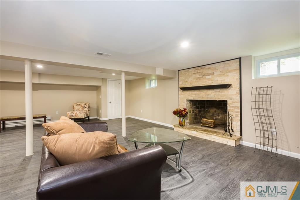 236 Spring Valley Road Morganville, NJ 07751 - Photo 11 of 23 a living room with furniture and a fireplace