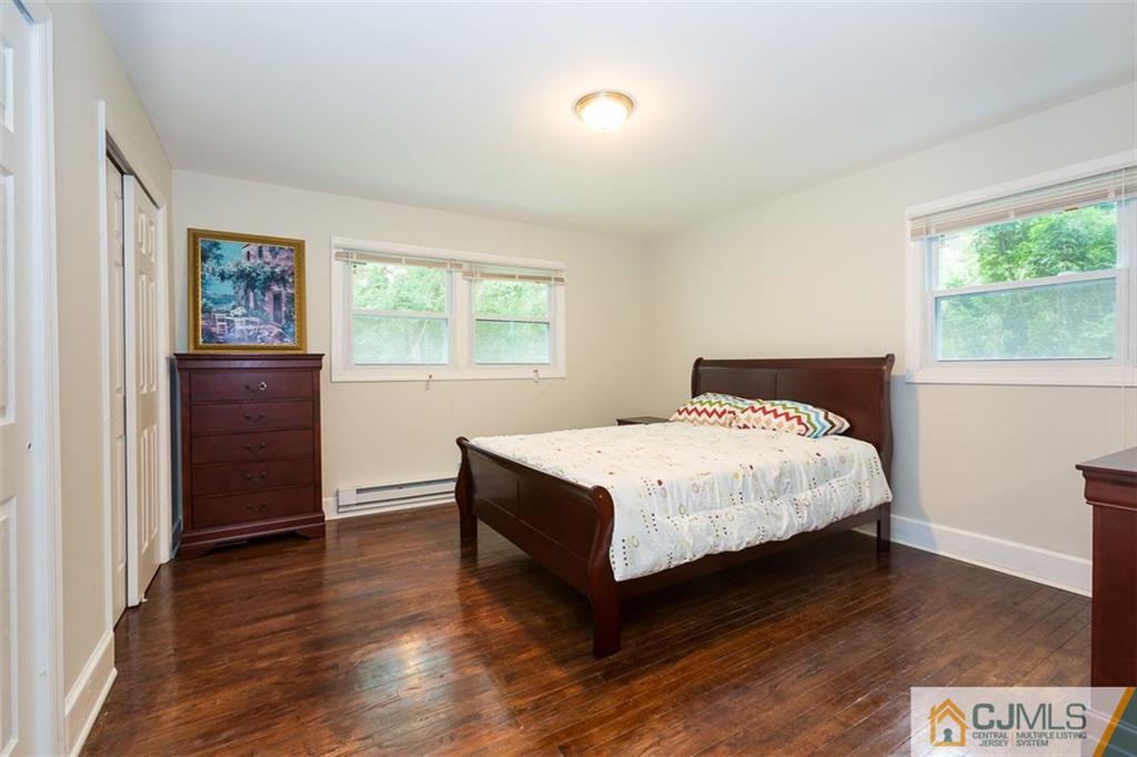 236 Spring Valley Road Morganville, NJ 07751 - Photo 12 of 23 a bedroom with a bed and wooden floor