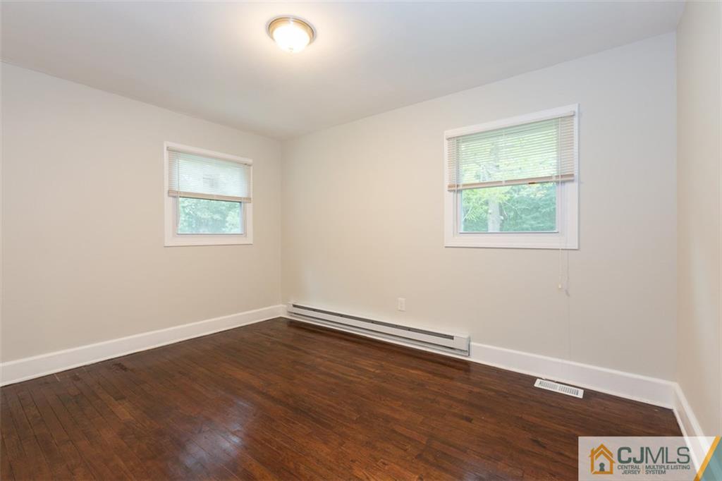 236 Spring Valley Road Morganville, NJ 07751 - Photo 15 of 23 wooden floor in an empty room with a window