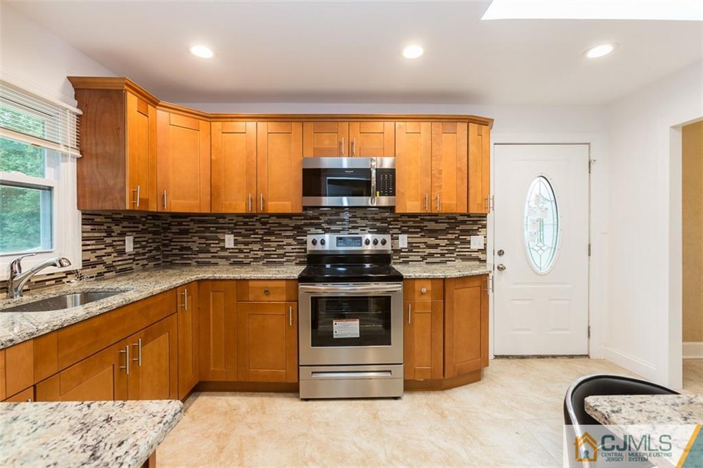 236 Spring Valley Road Morganville, NJ 07751 - Photo 4 of 23 a kitchen with stainless steel appliances granite countertop a stove a sink and a microwave