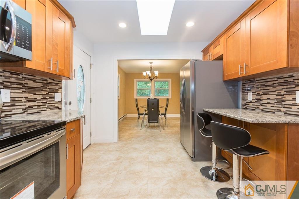 236 Spring Valley Road Morganville, NJ 07751 - Photo 5 of 23 a kitchen with kitchen island a stove and a microwave