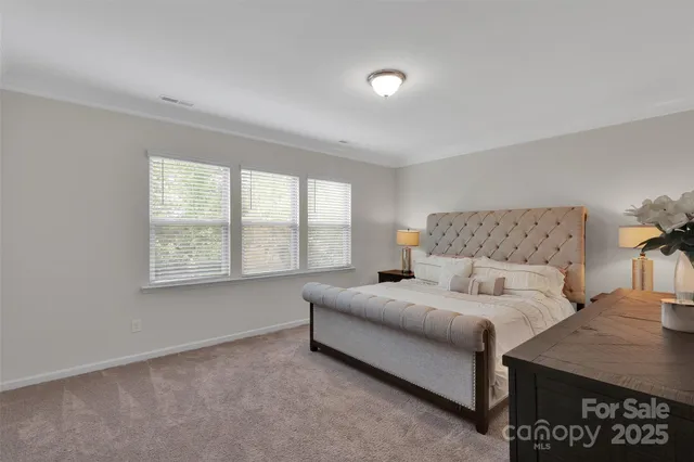 a bedroom with a bed and a lamp on dresser