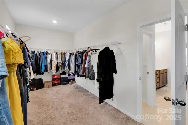 a view of walk in closet with clothes