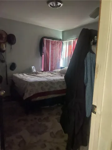 a bedroom with a bed and teddy bear on bed