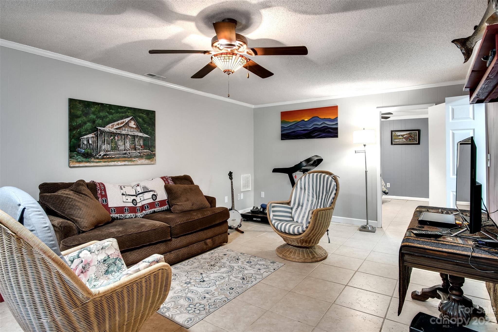 669 Walker Point Road Hayesville, NC 28904 - Photo 19 of 46 a living room with furniture a flat screen tv and a ceiling fan