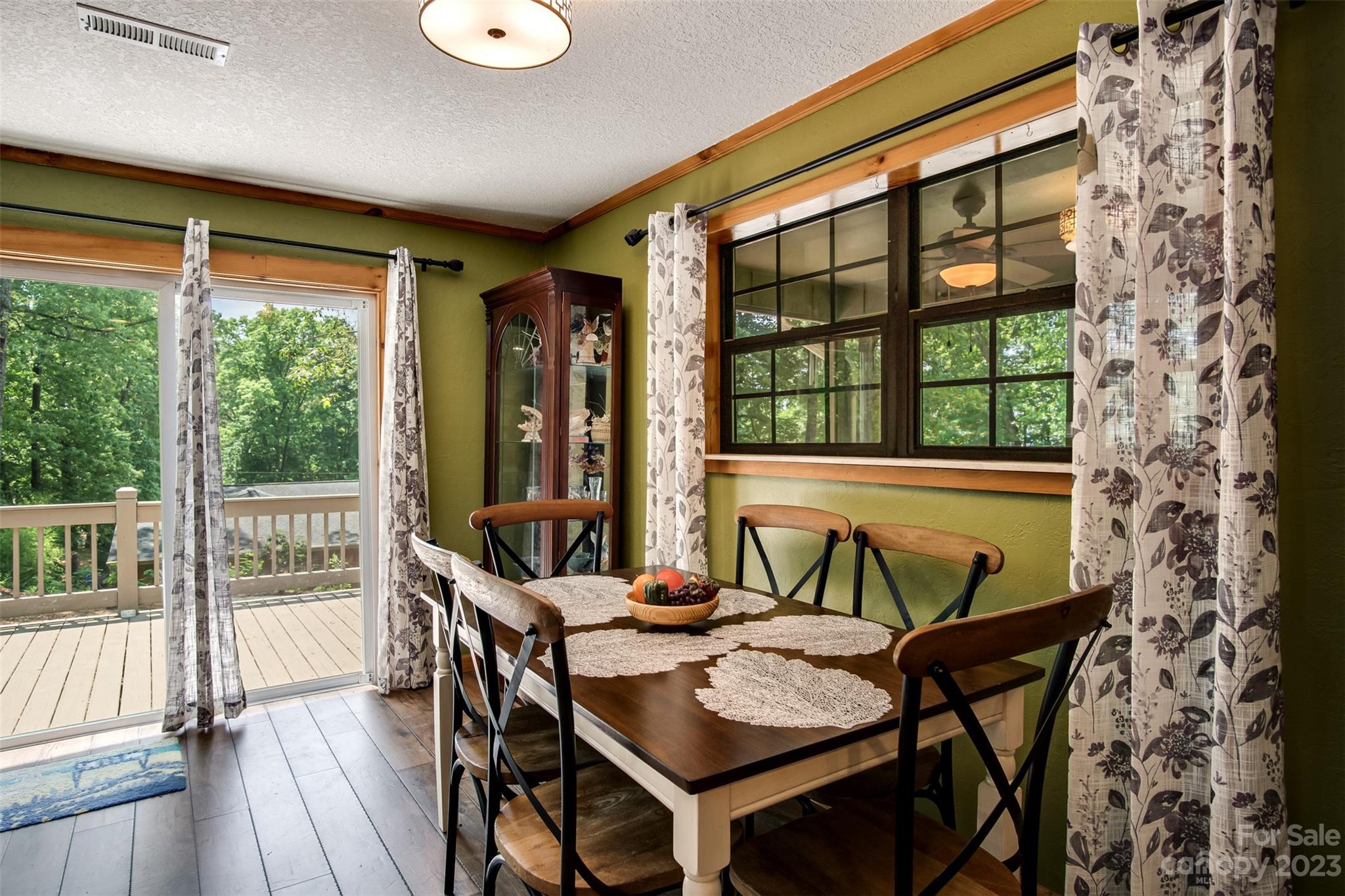 669 Walker Point Road Hayesville, NC 28904 - Photo 6 of 46 a view of a dining room with furniture large windows and wooden floor