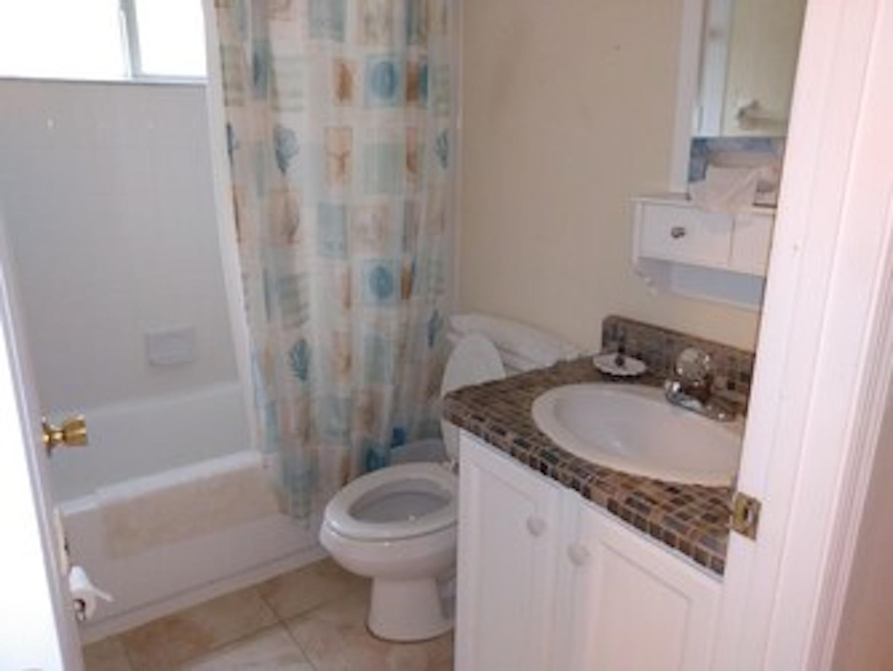 126 13th Street St. Augustine, FL 32080 - Photo 15 of 17 a bathroom with a granite countertop sink a toilet and shower