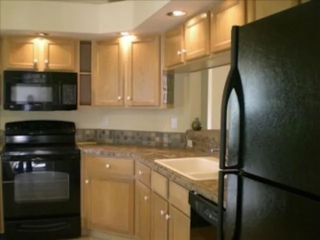 a kitchen with a sink a microwave and cabinets