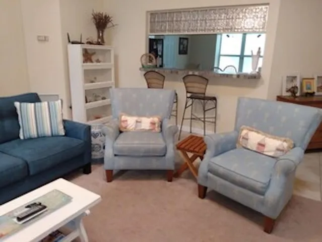 a living room with furniture a flat screen tv and a window