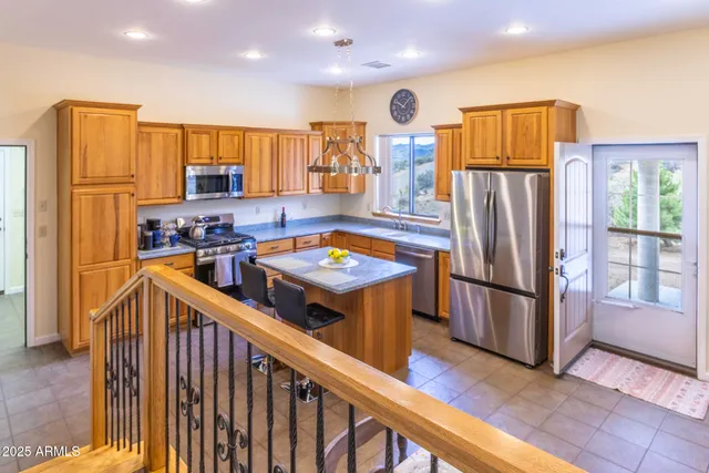 a kitchen with stainless steel appliances granite countertop a refrigerator a stove a sink and a refrigerator