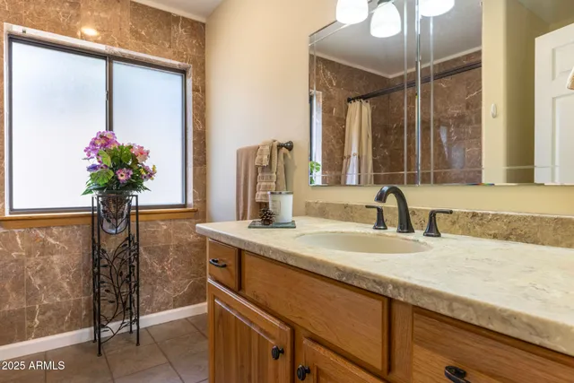 a bathroom with a granite countertop sink and a mirror
