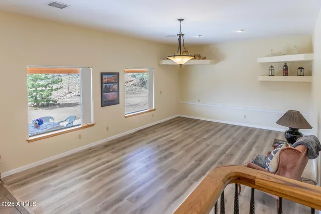 a living room with couches a dining table and chairs with wooden floor