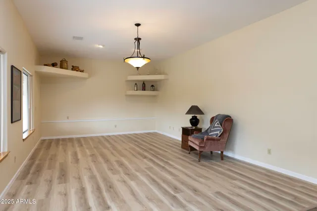 a view of a room with wooden floor table and chairs
