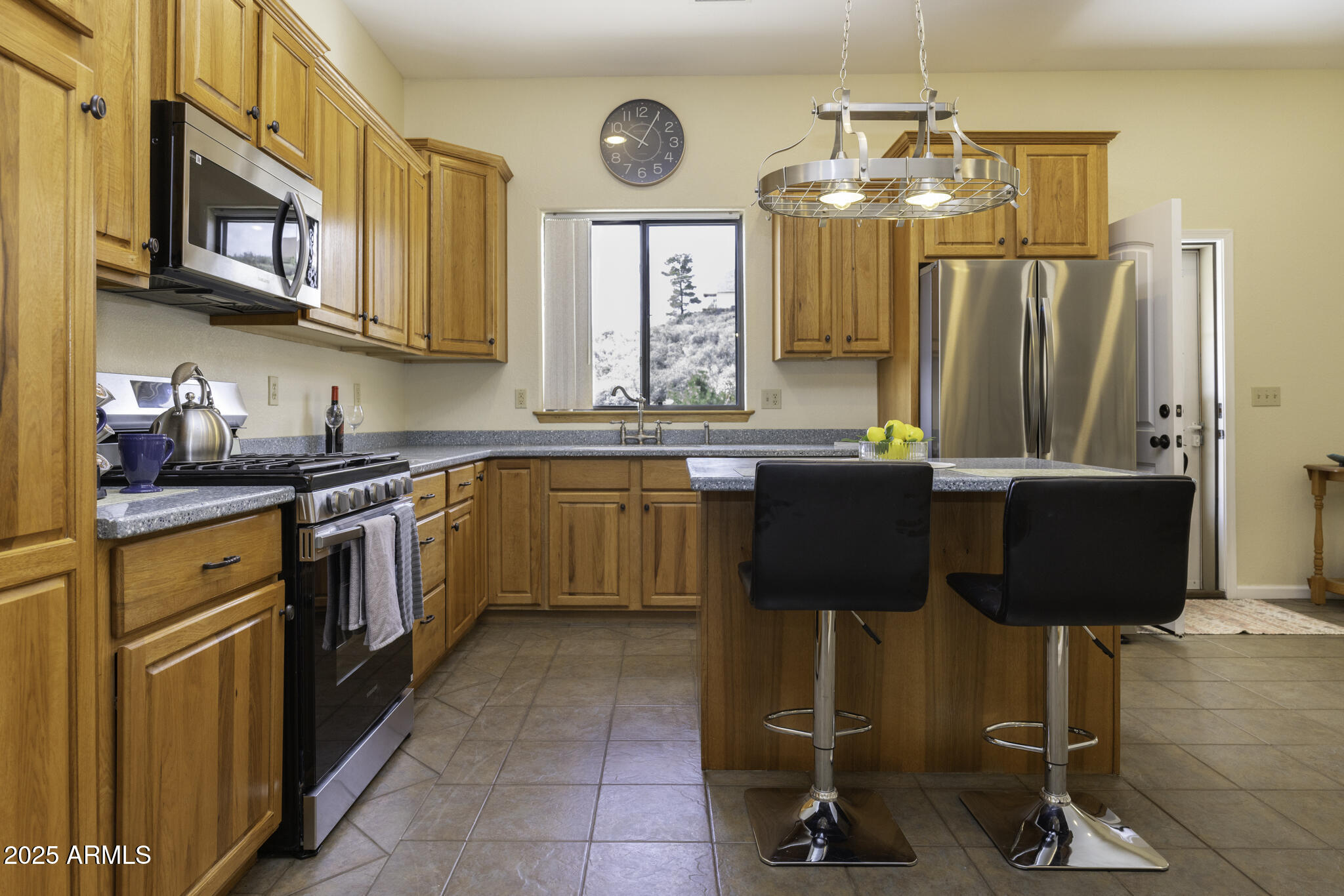18168 Spoon Road Peeples Valley, AZ 86332 - Photo 7 of 32 a kitchen with stainless steel appliances granite countertop a sink counter space cabinets and a window