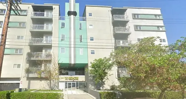 a balcony with table and chairs and potted plants