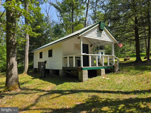 a view of a house with a yard chairs and floor to ceiling window