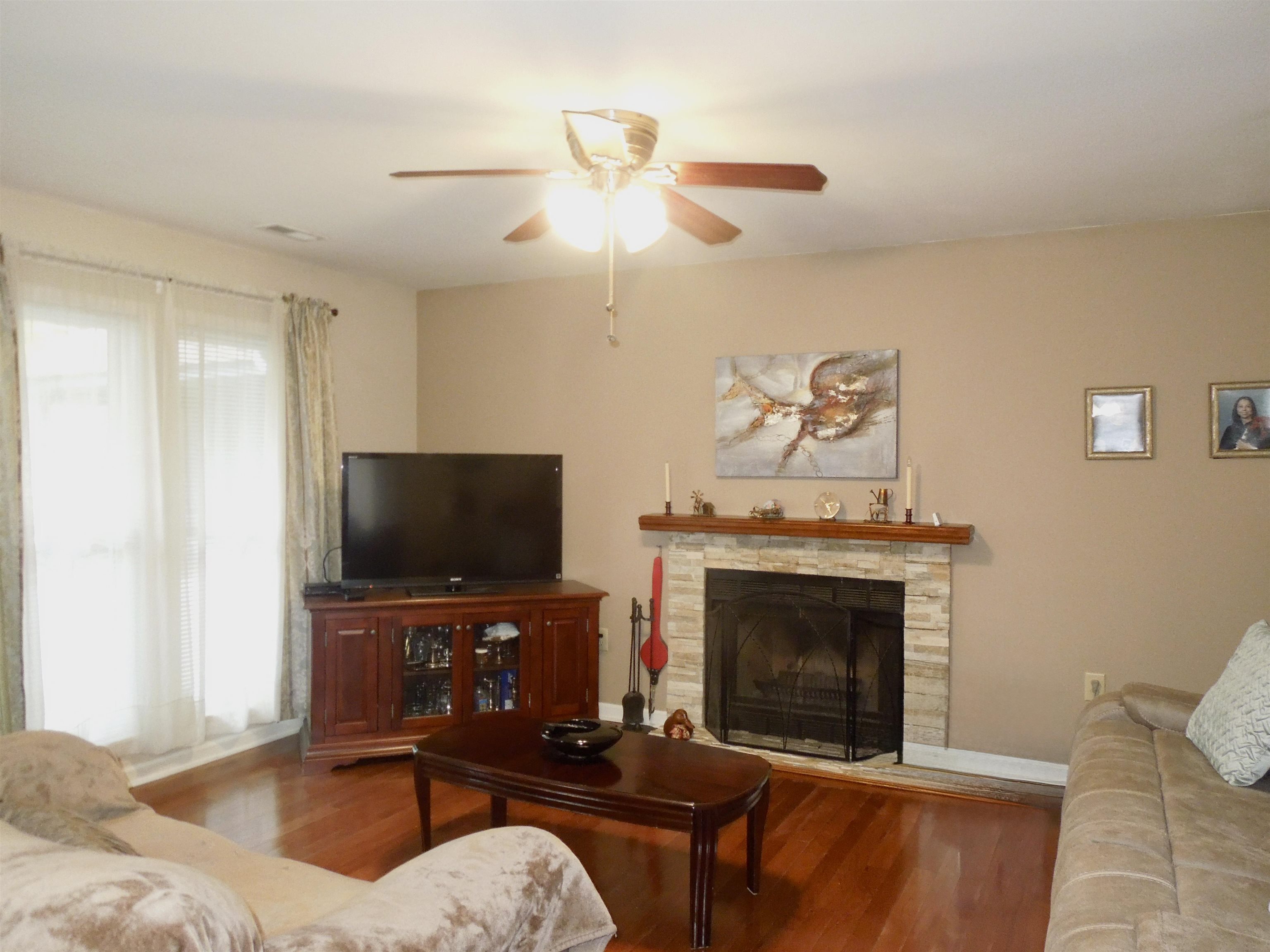 815 Willow Trace Myrtle Beach, SC 29572 - Photo 4 of 20 Living area featuring wood finished floors, a stone fireplace, and a ceiling fan