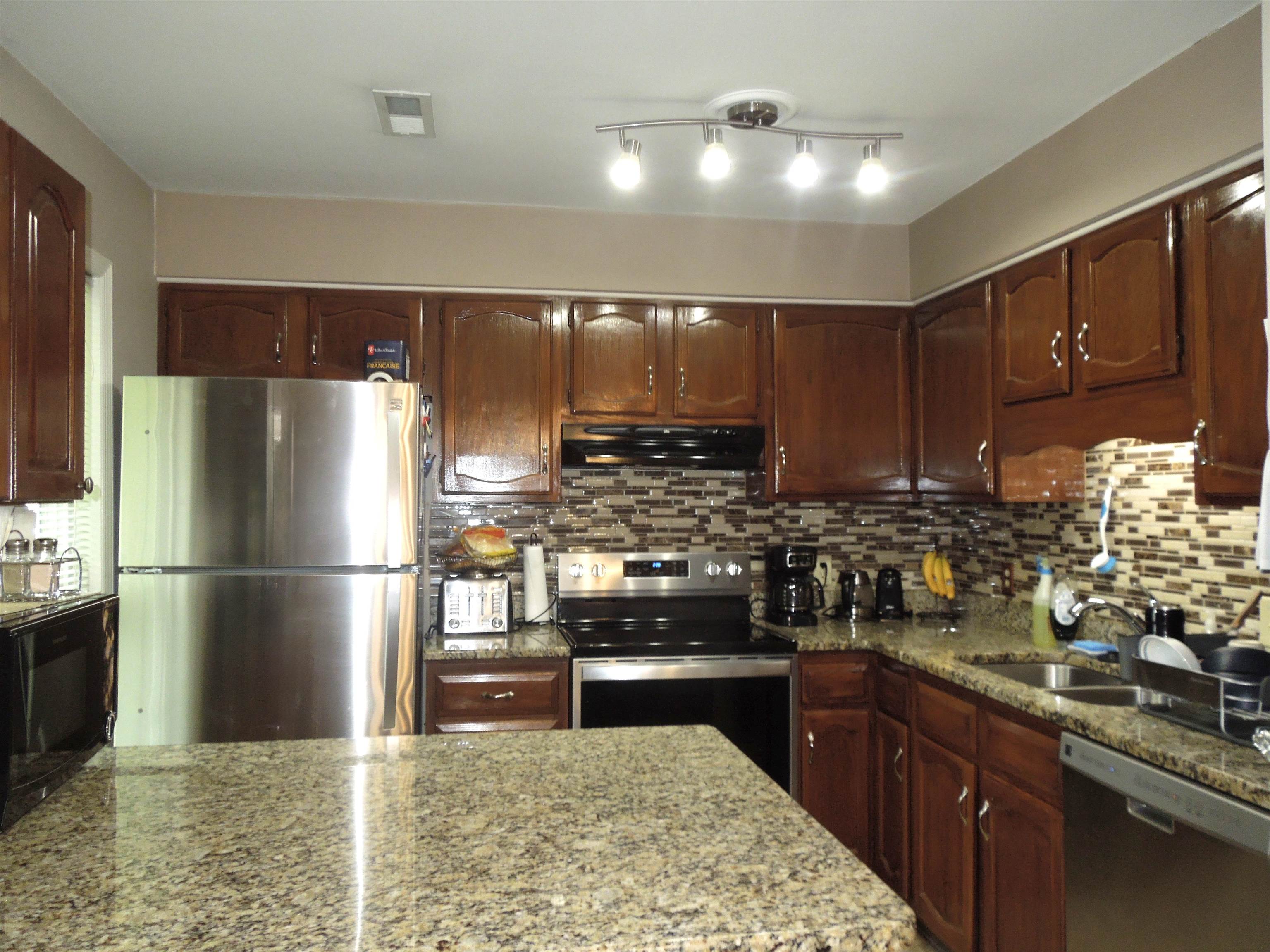815 Willow Trace Myrtle Beach, SC 29572 - Photo 7 of 20 Kitchen featuring appliances with stainless steel finishes, light stone counters, wall chimney exhaust hood, and decorative backsplash