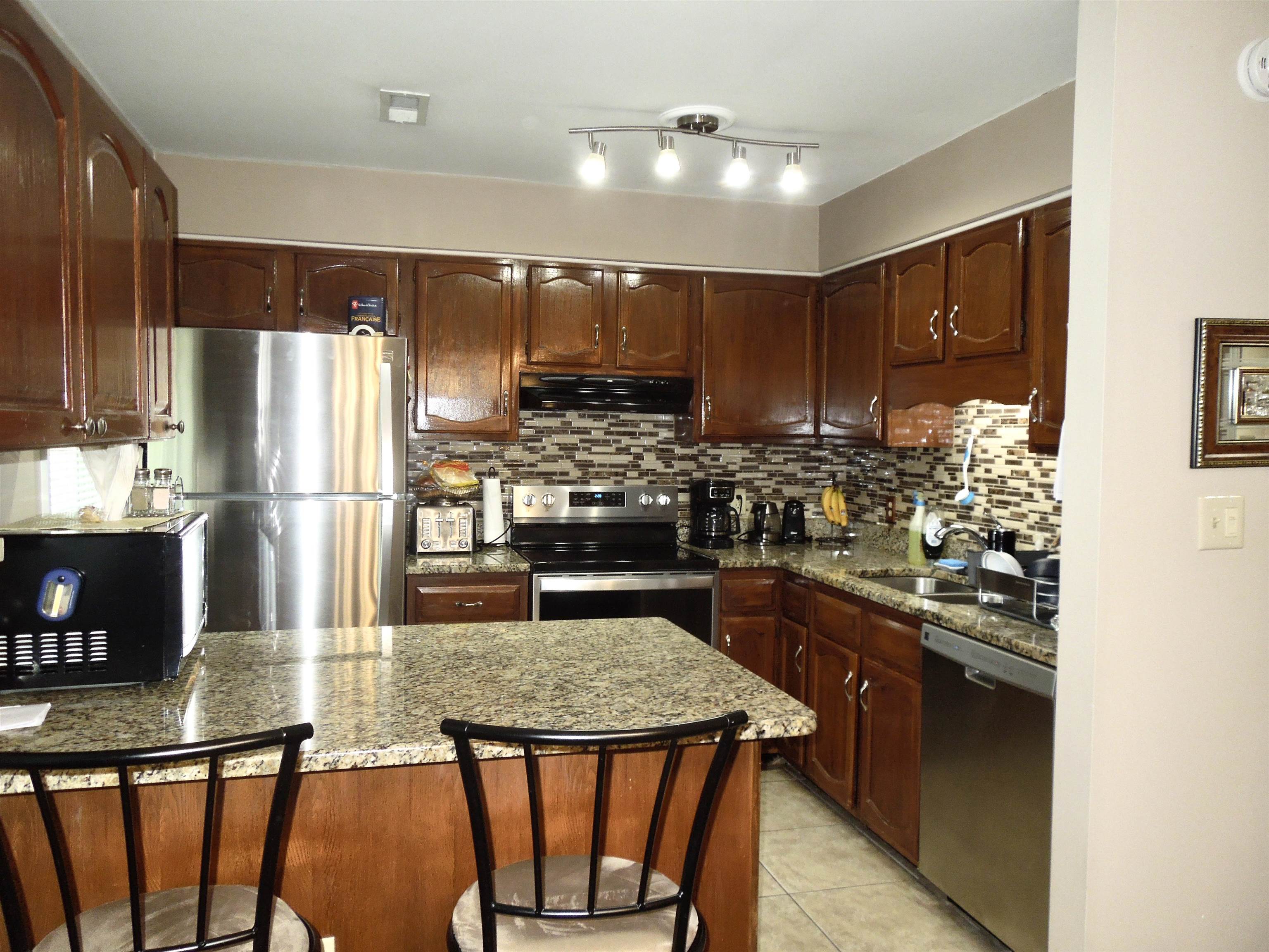 815 Willow Trace Myrtle Beach, SC 29572 - Photo 8 of 20 Kitchen featuring a breakfast bar area, appliances with stainless steel finishes, dark stone countertops, and light tile patterned floors