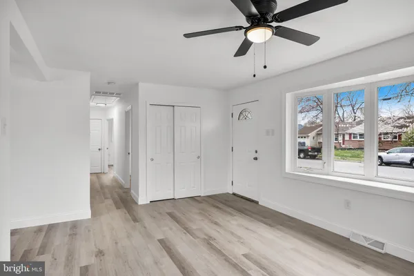 a view of an empty room with a window and a ceiling fan