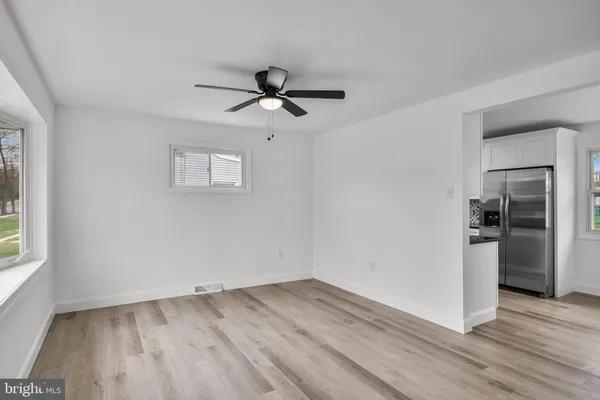 a view of empty room with wooden floor and window
