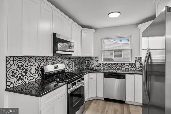 a kitchen with stainless steel appliances granite countertop a stove and a refrigerator