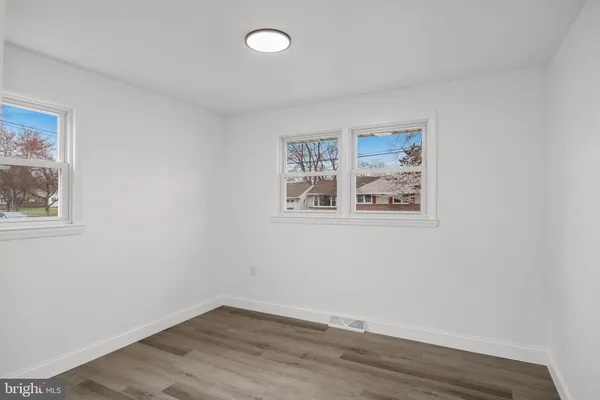 an empty room with wooden floor and window