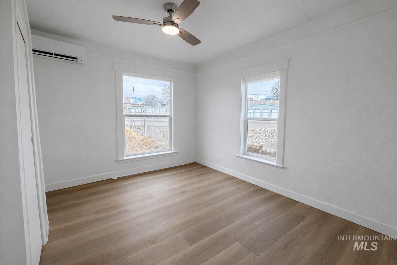 2 East Bates Avenue Parma, ID 83660 - Photo 6 of 7 Unfurnished bedroom featuring a closet, wood finished floors, a ceiling fan, and multiple windows