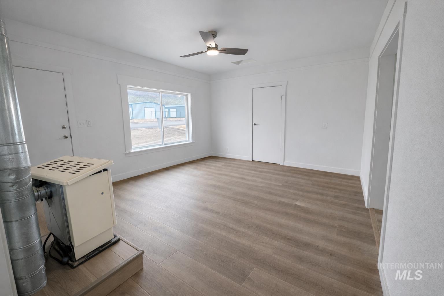 2 East Bates Avenue Parma, ID 83660 - Photo 7 of 7 Unfurnished living room with ceiling fan and light wood-type flooring