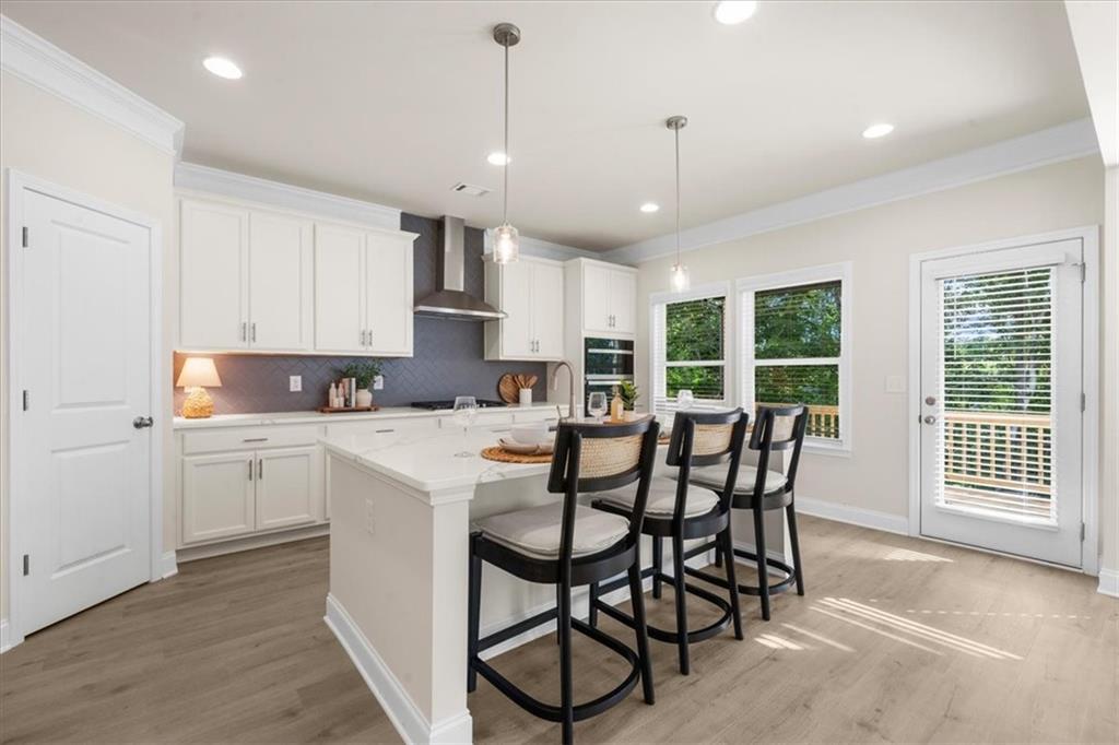 8620 Standing Stone Ball Ground, GA 30107 - Photo 20 of 61 a kitchen with stainless steel appliances granite countertop a stove a refrigerator a microwave a dining table and chairs with wooden floor