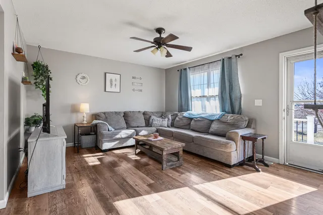 a living room with furniture a chandelier and a window