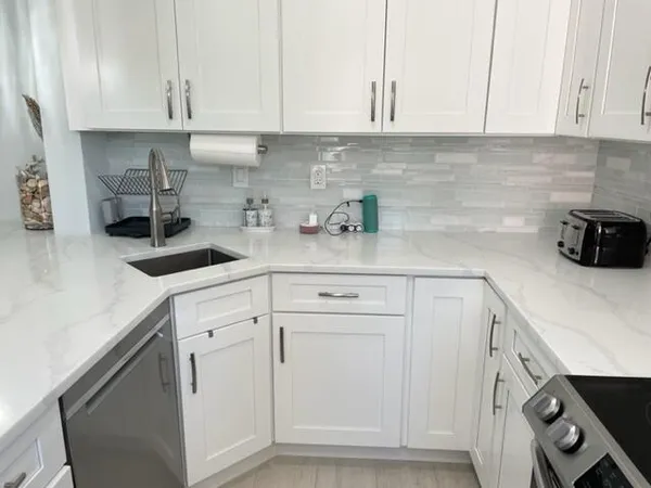a kitchen with white cabinets and white appliances