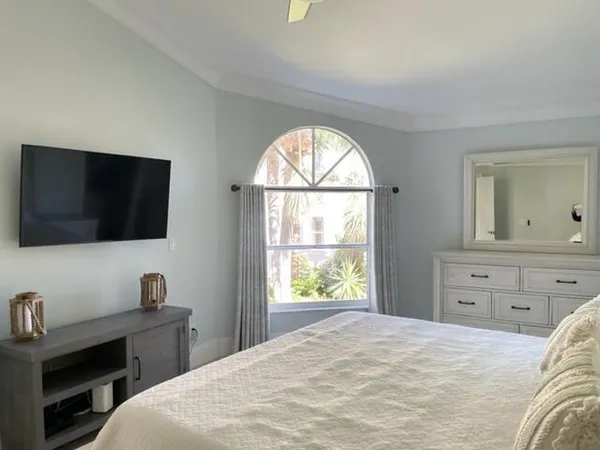 a bedroom with a large bed and a flat screen tv