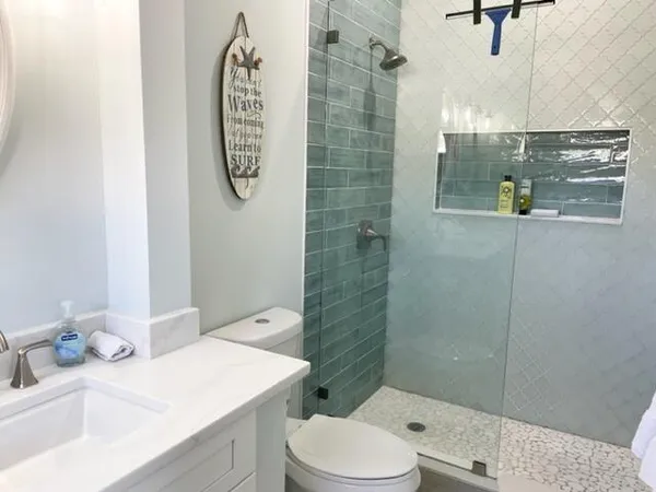 a bathroom with a sink a toilet and shower