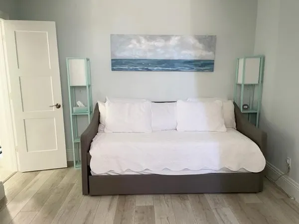 a bedroom with a bed and wooden floor