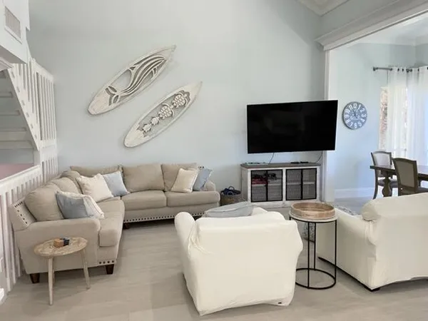 a living room with furniture a flat screen tv and a window