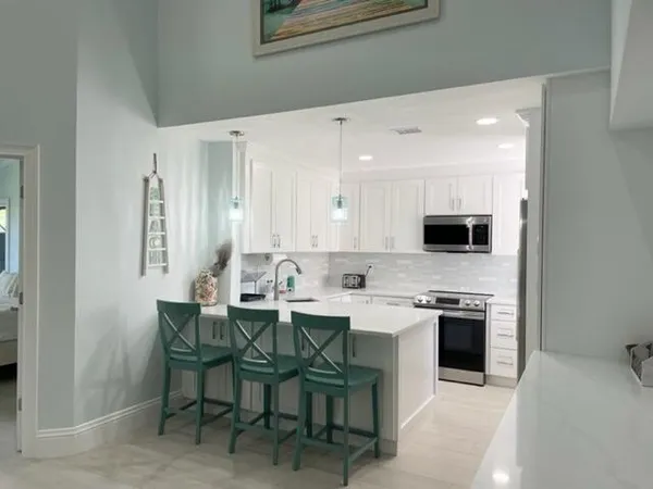 a kitchen with a sink a microwave and cabinets