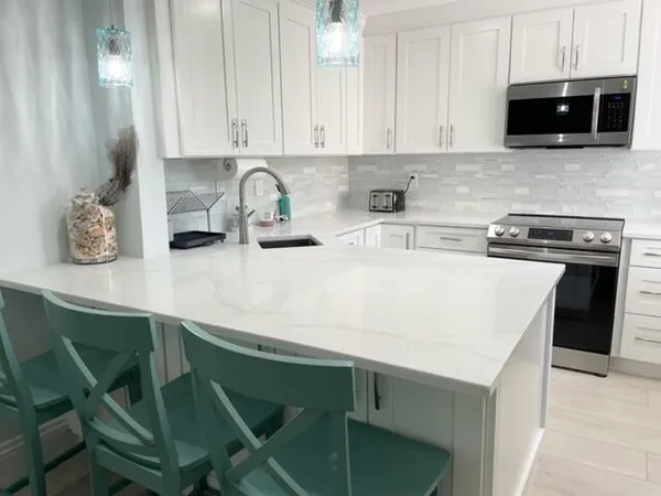 a kitchen with stainless steel appliances a stove a sink a microwave and cabinets