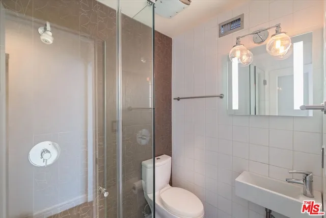 a bathroom with a toilet sink shower and mirror