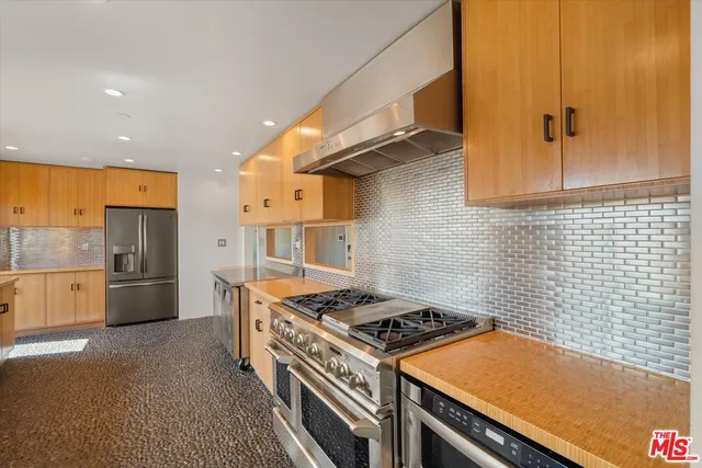 a kitchen with stainless steel appliances a stove a sink and a refrigerator