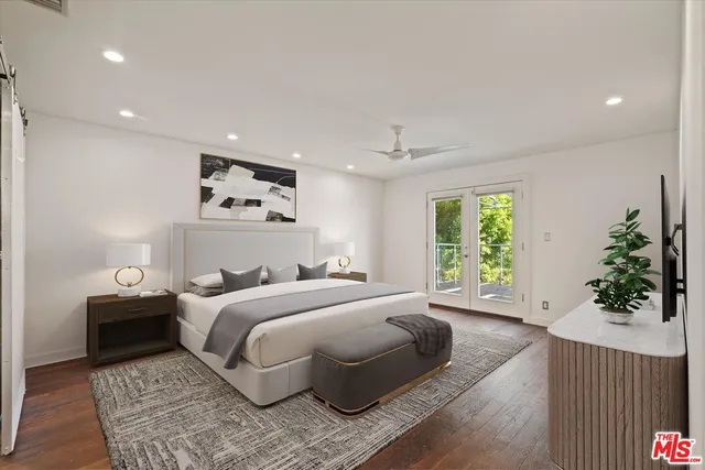 a bedroom with a large bed and a potted plant