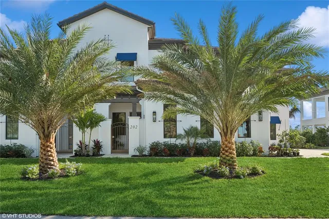 a view of a white house with a big yard and large tree