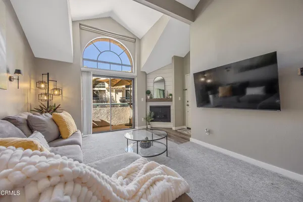 a living room with furniture a flat screen tv and a large window
