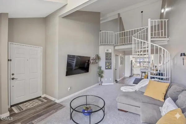a living room with furniture a flat screen tv and a window